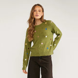 Model i grøn pullover med farverige broderede blomster, set forfra fra hofterne og op