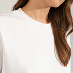 Nærbillede af den runde hals med ribkant på den hvide Nugira t-shirt