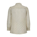 Hvid skjorte med små sorte blomster og smock ved håndleddet, set bagfra