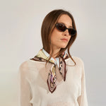 Nærbillede af flerfarvet tørklæde bundet med knude ved halsen, set lidt fra siden
