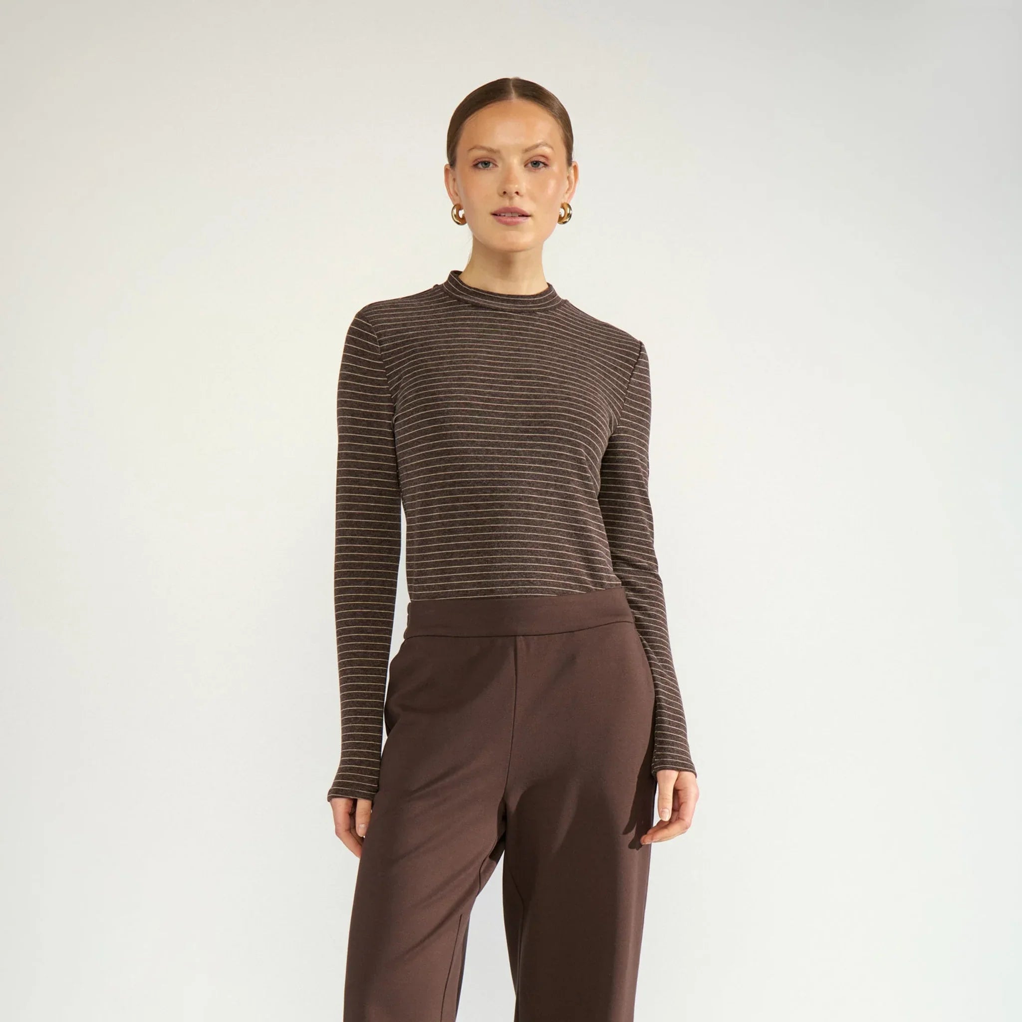 Model i brun stribet Nulanis bluse set forfra i hel figur, stylet med brune bukser