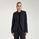 Model i navy nålestribet blazer med fitted snit over sort t-shirt, set forfra