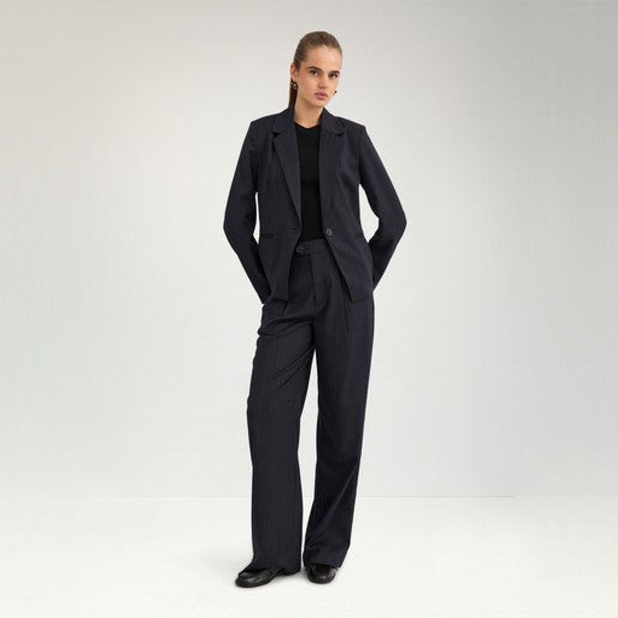 Model i hel figur i navy nålestribet blazer stylet med bukser i samme stribe