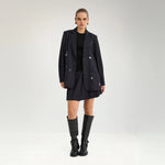 Model i navy oversize blazer med nålestriber stylet med kort nederdel og sorte støvler