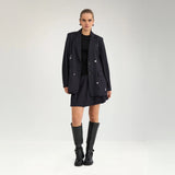 Model i navy oversize blazer med nålestriber stylet med kort nederdel og sorte støvler
