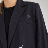 Nærbillede af navy blazer med hvid svane, stjerne og hjerte ved brystlommen