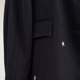 Nærbillede af lomme med klap og hvid stjerne og rose på navy nålestribet blazer