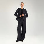 Model i navy nålestribede wide leg bukser og matchende blazer med sort t-shirt og loafers