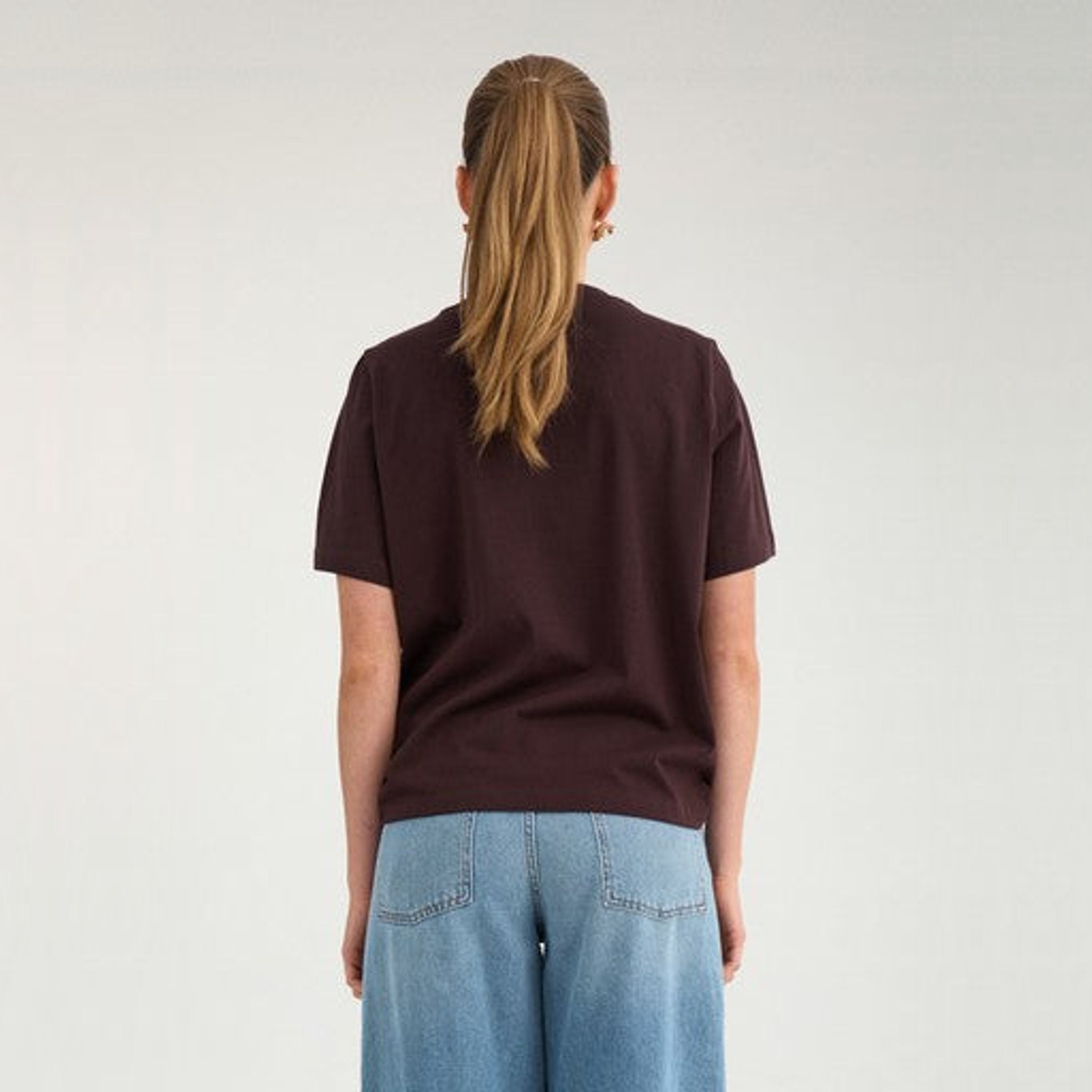 Model i brun t-shirt fra Nümph set bagfra med lyse jeans