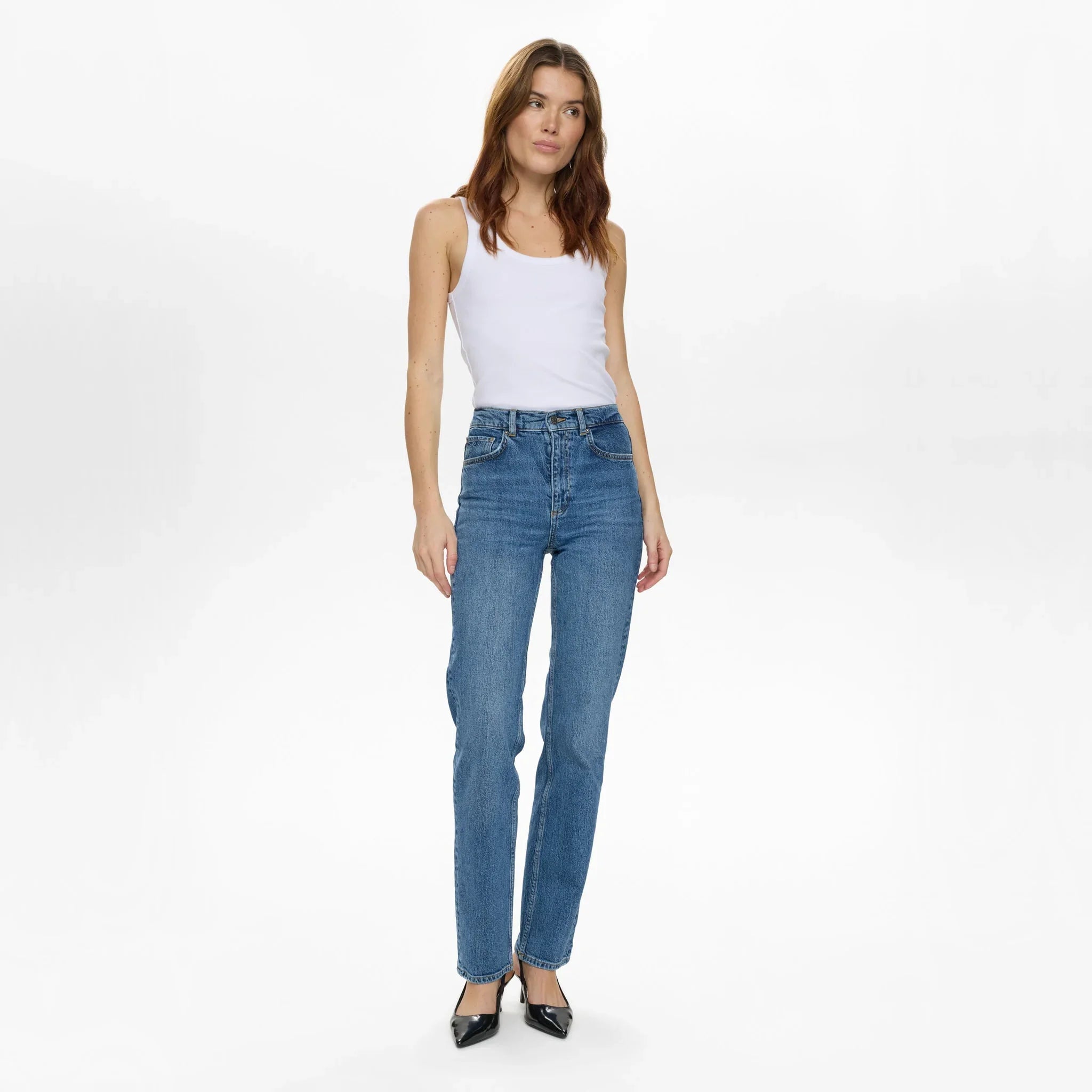 Model i blå straight jeans med høj talje fra Nümph, stylet med hvid tanktop, set forfra