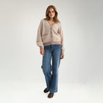 Model i fuld figur i grå og cremehvid stribet cardigan med vide blå jeans