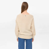 Model i beige pullover set bagfra med vide ærmer og ribkant
