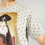 Nærbillede af fotoprint med hund i perlekæde og sorte prikker på grå t-shirt