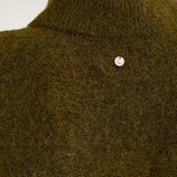 Nærbillede af krave og lille logo bag i nakken på grøn cardigan i fluffy strik