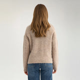 Model i beige strik set bagfra med ribkant forneden og på ærmerne
