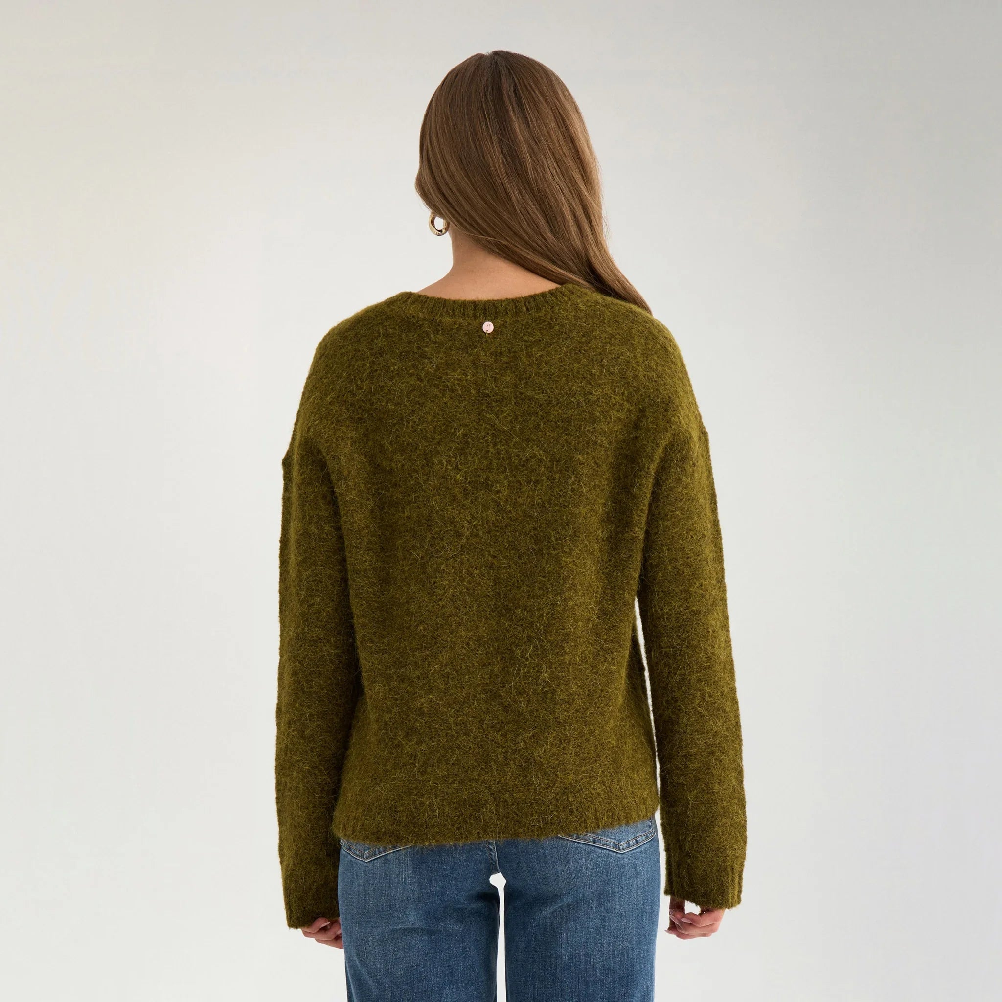 Model i grøn strik Nusalia set bagfra med jeans