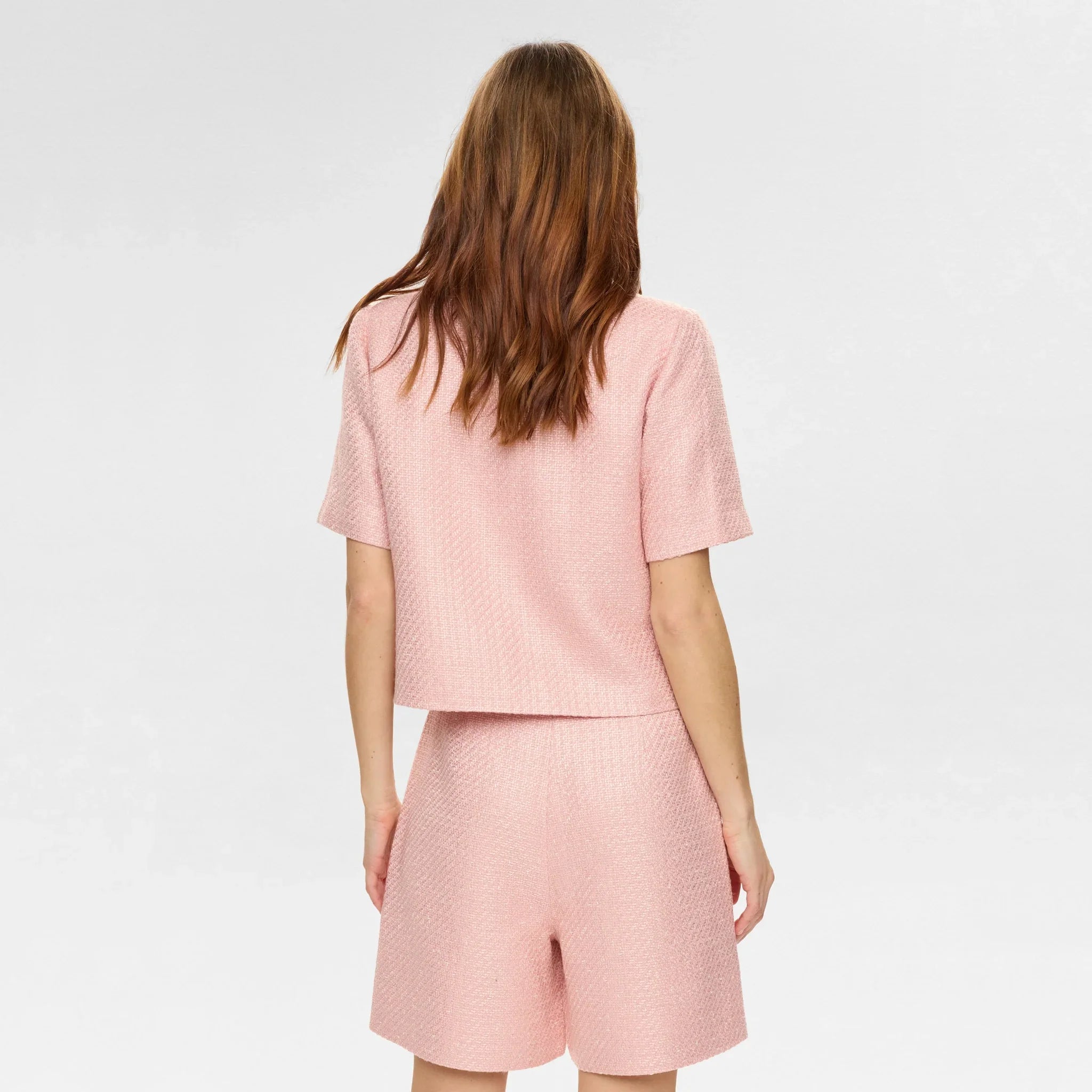 Model set bagfra i kort pink jakke fra Nümph med korte ærmer