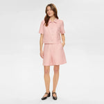 Hel figur af model i pink Nushana jakke med lyserøde shorts og sorte sko