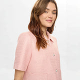 Tæt på model i pink jakke i Peony med krave og perlelignende knapper