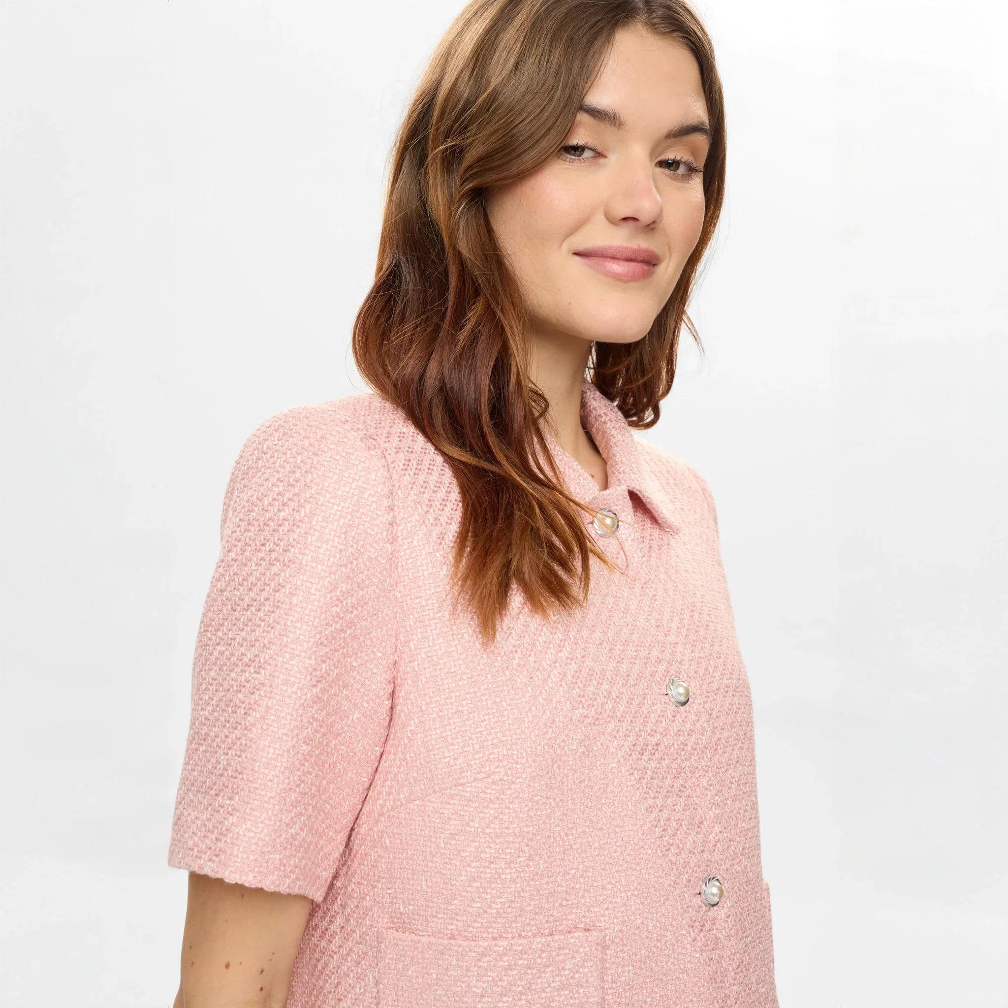 Tæt på model i pink jakke i Peony med krave og perlelignende knapper