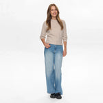 Model i hel figur i grå børstet strik fra Nümph med wide leg jeans og sorte loafers