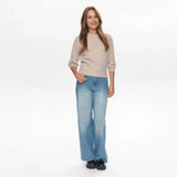 Model i hel figur i grå børstet strik fra Nümph med wide leg jeans og sorte loafers