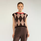 Model i brun og beige argyle vest med rød halskant, stylet med brune bukser, set forfra