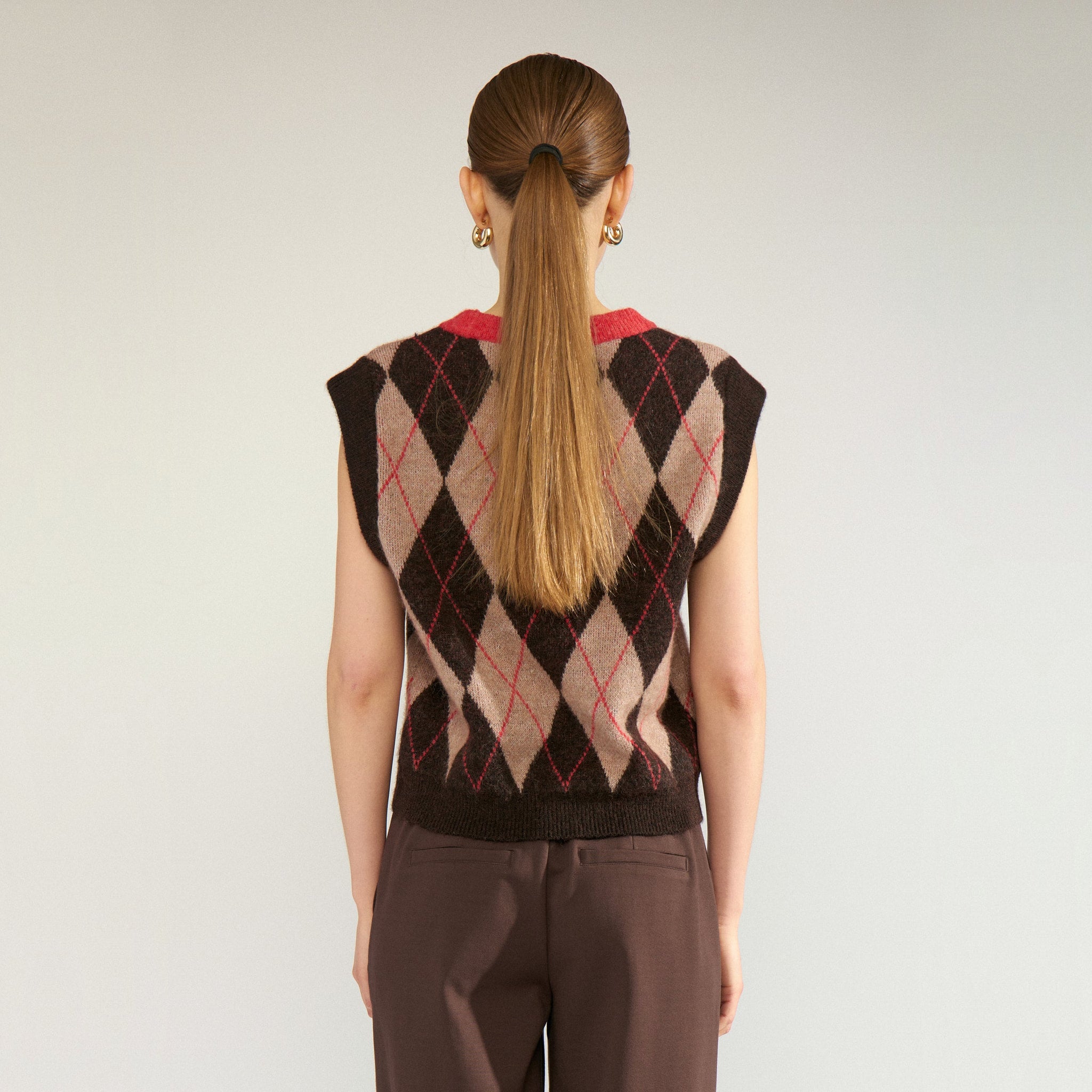Model set bagfra i ærmeløs strikket vest med brunt og beige argylemønster