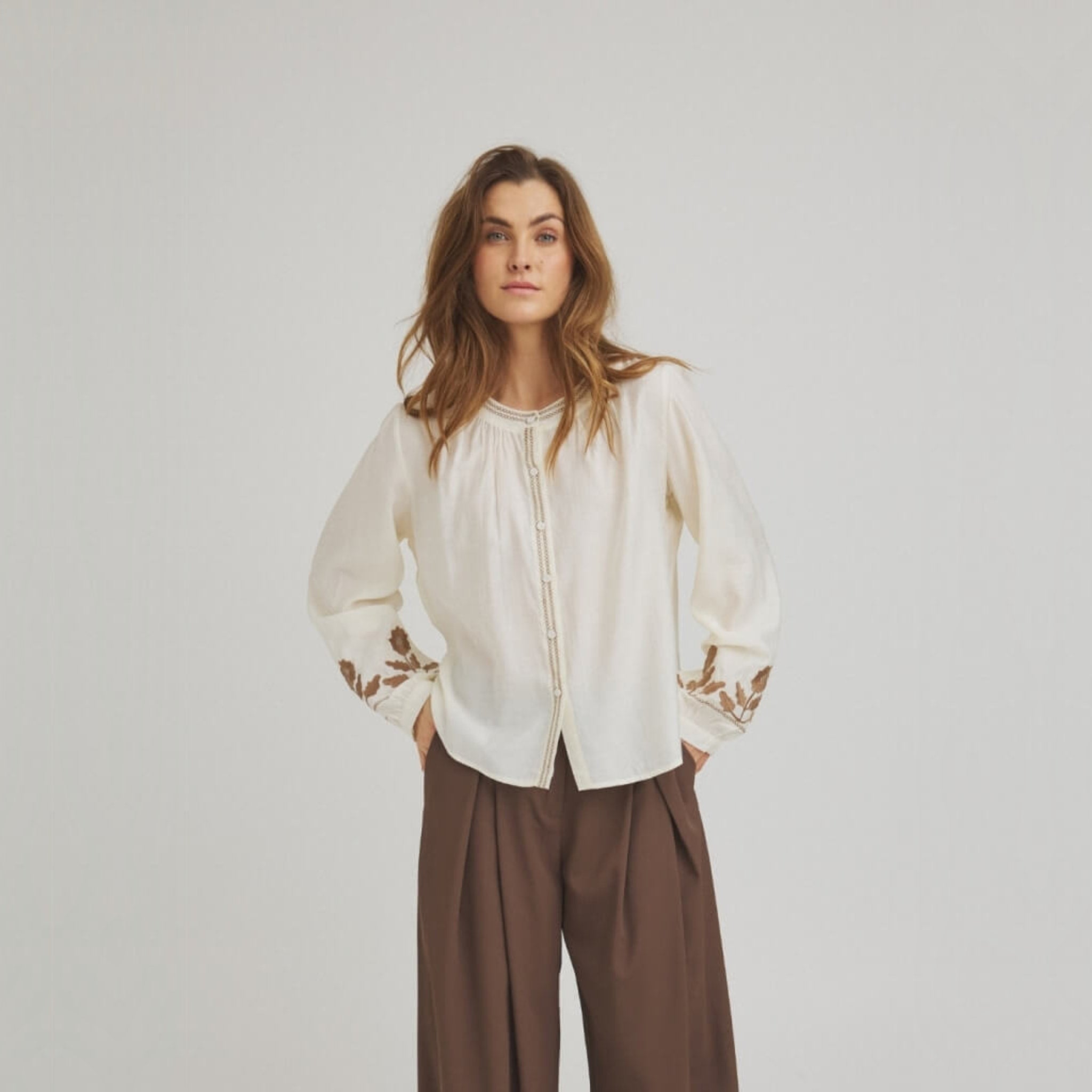 Hvid skjorte Allice Shirt i Offwhite med brune broderier på ærmerne og broderet kant foran, set forfra på model