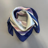 Blåt tørklæde Bandito Scarf i Blue Heron med mørkeblå kant og striber i lyserød, lilla og hvid, foldet og knyttet