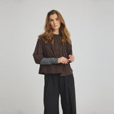 Model i brun bluse Percha Blouse fra OneTwo Luxzuz stylet med vide sorte bukser
