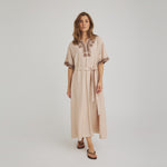 Model i beige Vava Dress kjole fra OneTwo Luxzuz med brune broderier og bindebælte, set forfra