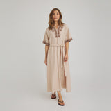 Model i beige Vava Dress kjole fra OneTwo Luxzuz med brune broderier og bindebælte, set forfra