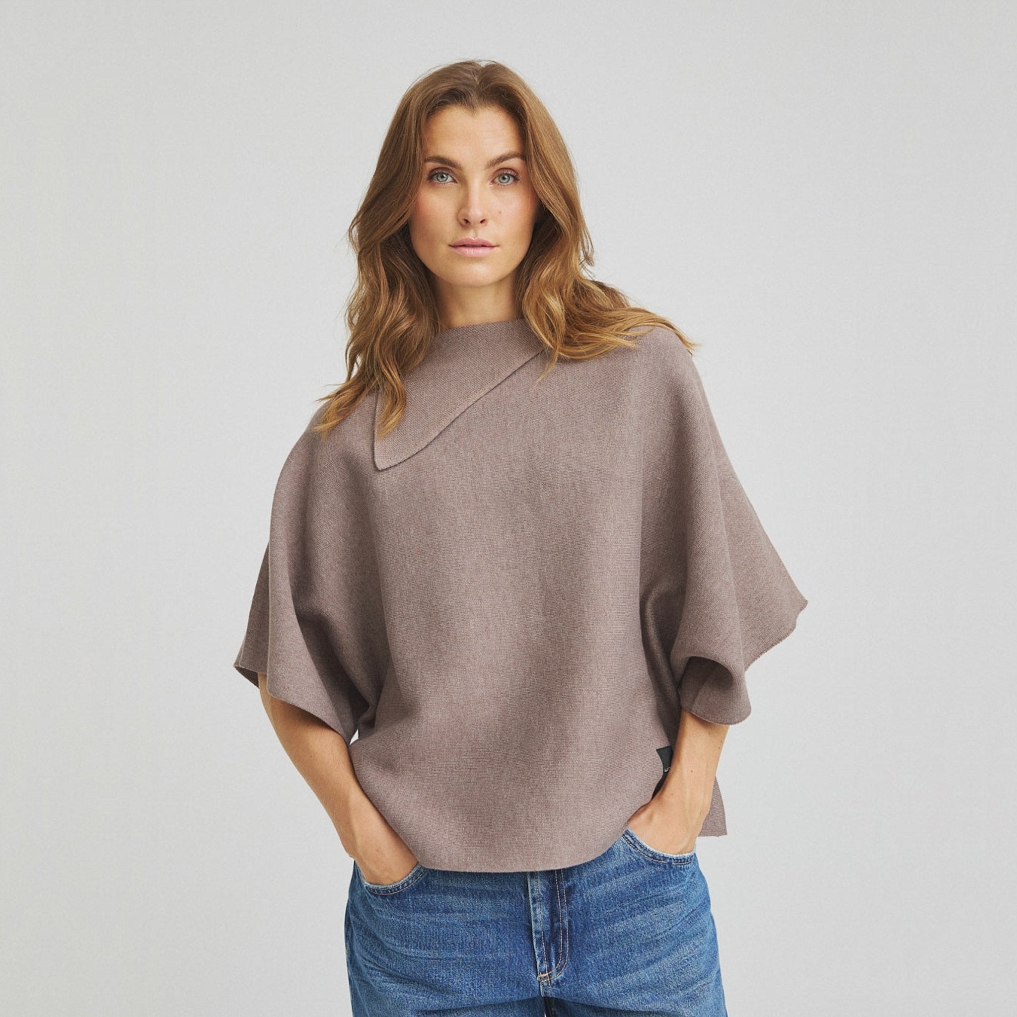 Model i grå Zana Knit strik fra OneTwo Luxzuz i Rain Drum stylet med blå jeans