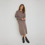 Model i grå midi nederdel i strik fra OneTwo Luxzuz stylet med matchende strik, stribet bluse og loafers