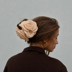 Model set bagfra med beige satinrose-hårklemme fra Pico i en løs knold