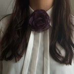 Lilla organza-rose i Dark Plum båret som halskæde under kraven på en hvid skjorte