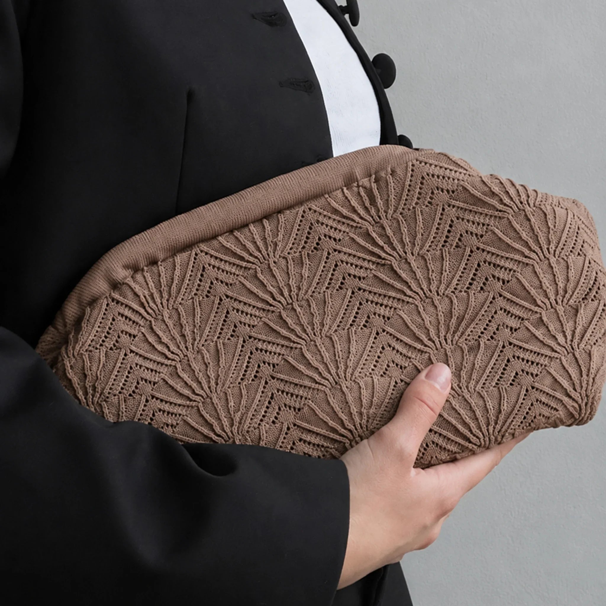 Model holder brun Shelly Clutch taske med muslingemønster under armen til sort blazer
