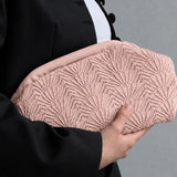 Model holder pink Shelly Clutch fra Pico under armen sammen med sort blazer og hvid top