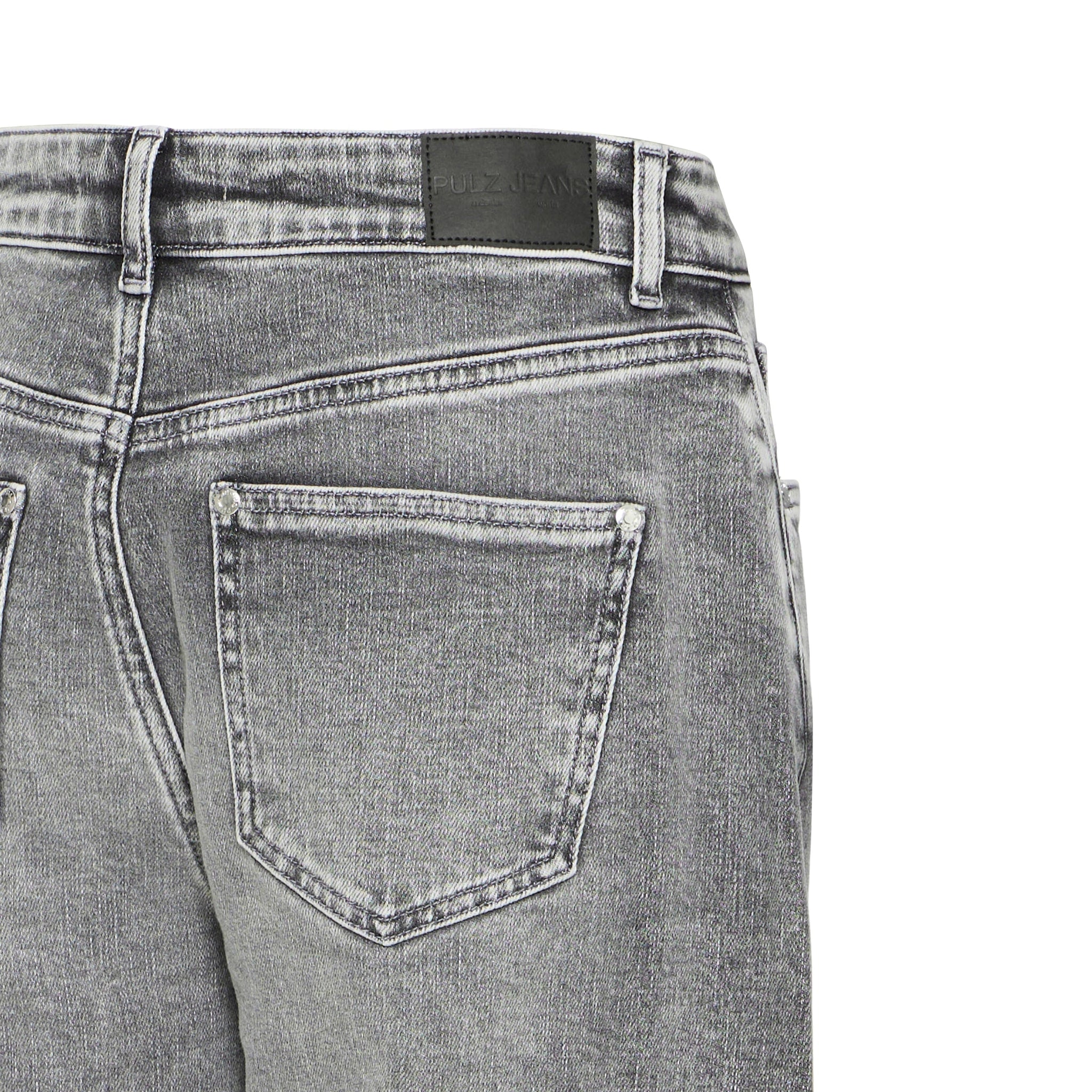 Nærbillede af baglomme og Pulz Jeans-mærkat på linningen af grå jeans