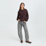 Model i grå barrel leg jeans med brun strikbluse og brune støvler, hele figuren