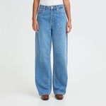 Tæt på model i blå wide leg jeans set forfra med brede ben og knaplukning