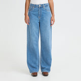Tæt på model i blå wide leg jeans set forfra med brede ben og knaplukning