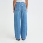 Model i blå wide leg jeans set bagfra med baglommer og brede ben