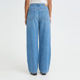 Model i blå wide leg jeans set bagfra med baglommer og brede ben