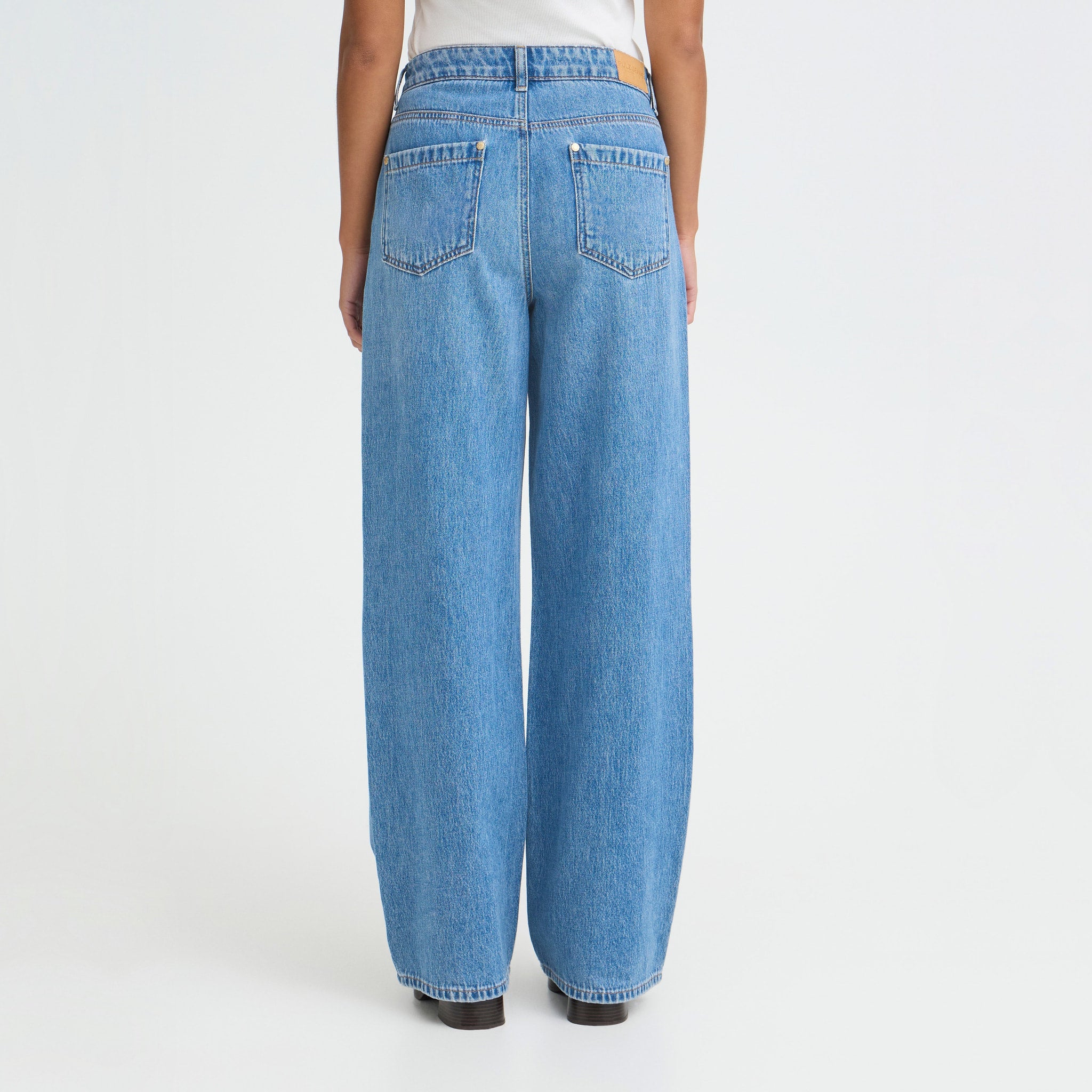 Model i blå wide leg jeans set bagfra med baglommer og brede ben