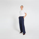 Model i navy wide leg bukser med høj talje og hvid t-shirt, med hænderne i lommerne