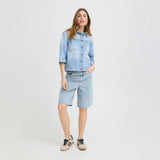 Model i lyseblå lange denimshorts fra Pulz med vide ben, set forfra i hel figur