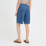 Model i blå denimshorts Bridget fra Pulz med lange, vide ben, set bagfra