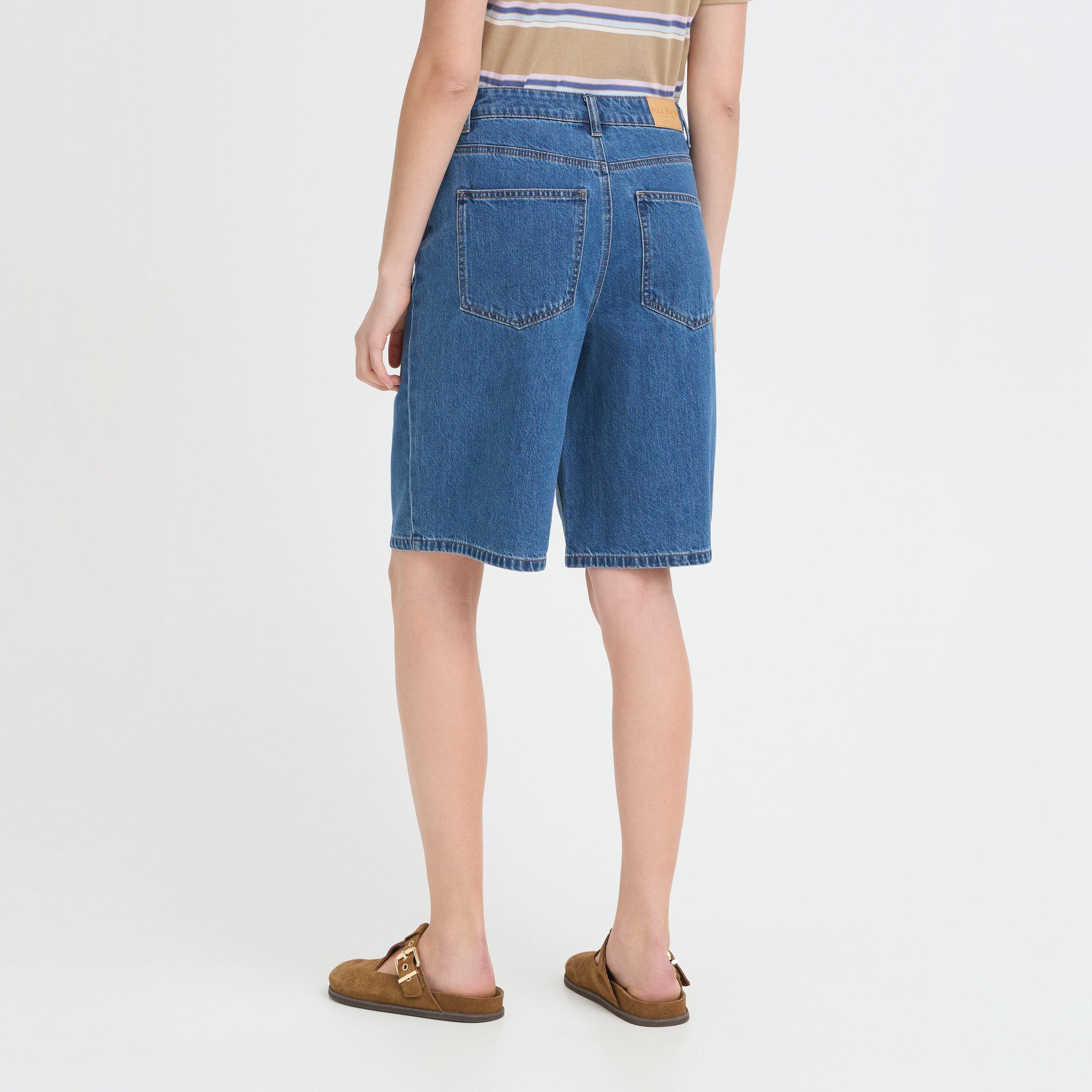 Model i blå denimshorts Bridget fra Pulz med lange, vide ben, set bagfra